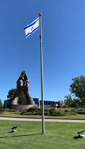 Staty med händer som ber och Israels flagga