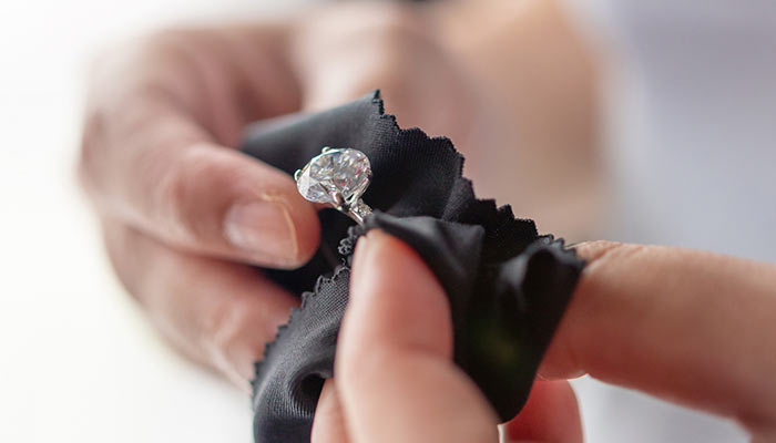 Hands polishing a custom engagement ring