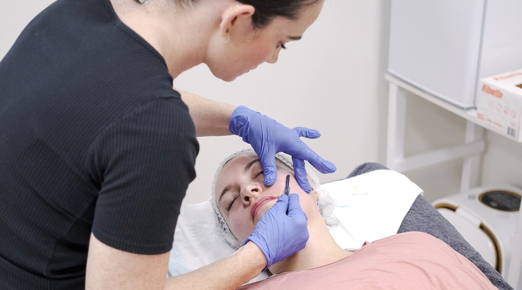 Woman performing a Dermaplaning treatment at a short beauty course in Brisbane. 