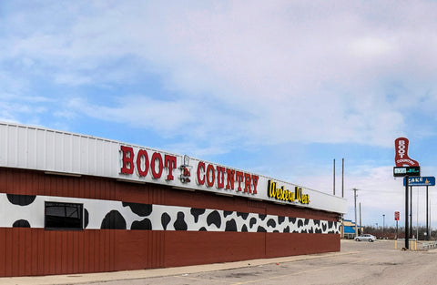 store front red building cow print detail and boot country western wear sign