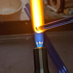 glass rod being melted in a flame