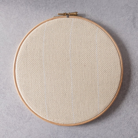 Fabric stretched in an embroidery hoop for punch needle