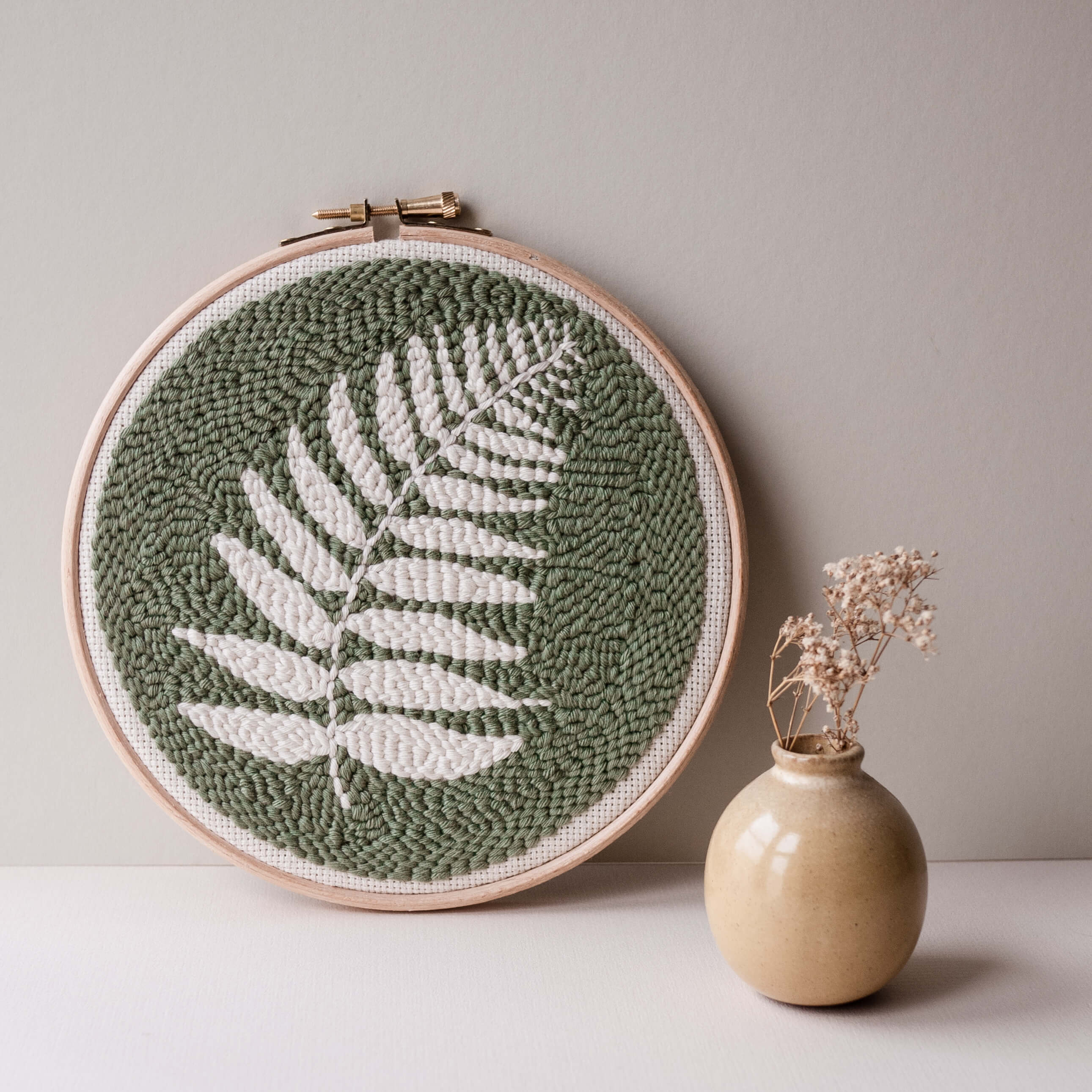 Fern punch needle hoop in sage green with small ceramic vase