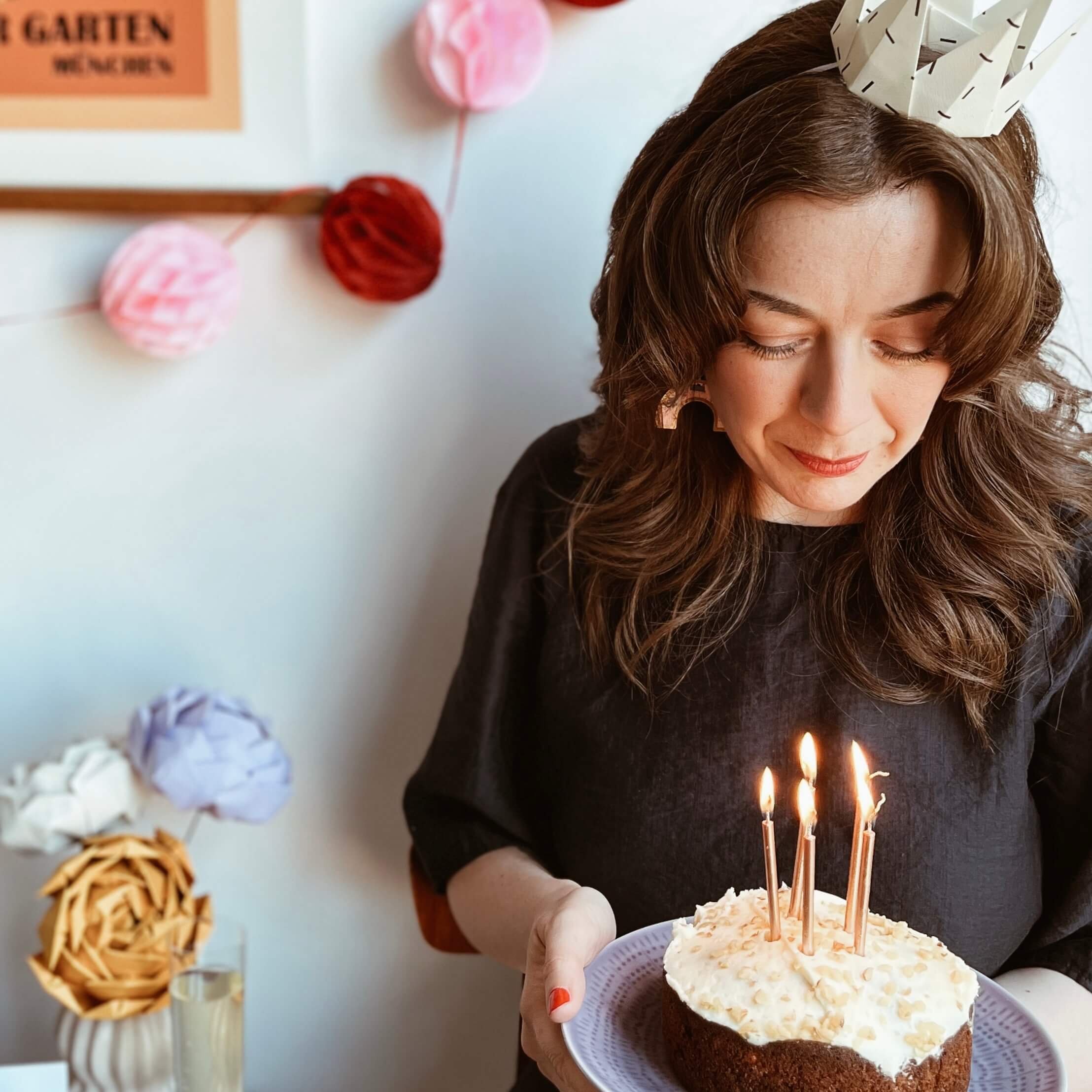 Sara Moore of Whole Punching, holding a birthday cake with candles