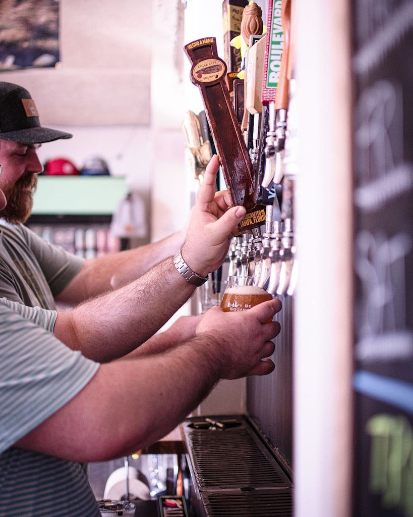 Photo of a person filling a beer at a tap. 