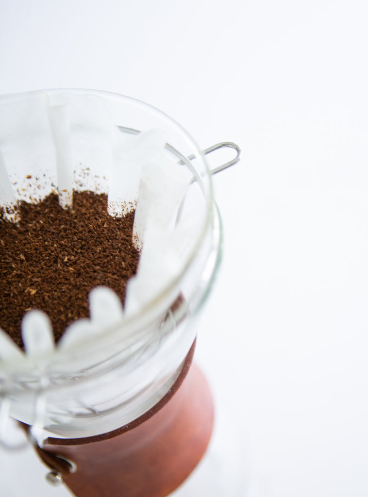 Photo of coffee grounds in a filter in a pour-over device.