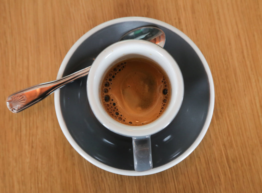 Top down image of espresso in a small cup on a saucer.