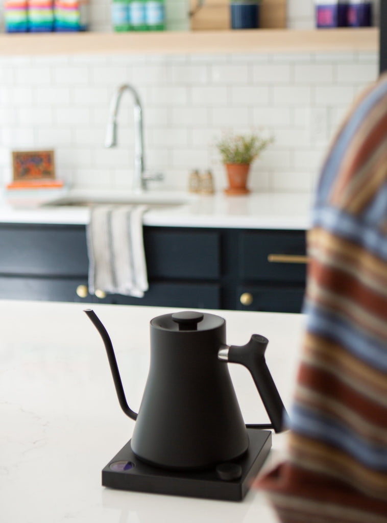 Photo of an electric, gooseneck kettle on a kitchen counter.