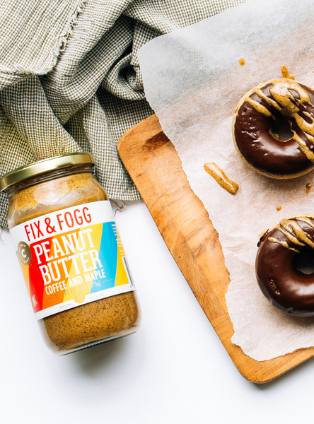 Top down photo of a jar of Counter Culture Coffee x Fix & Fogg Maple Peanut Butter next to a board with doughnuts on it.