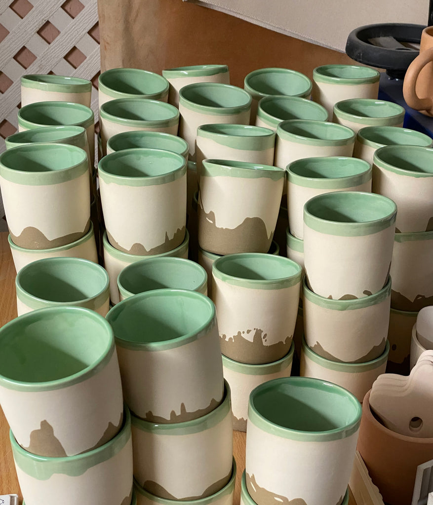 Photo of a large stack of many LA mugs.