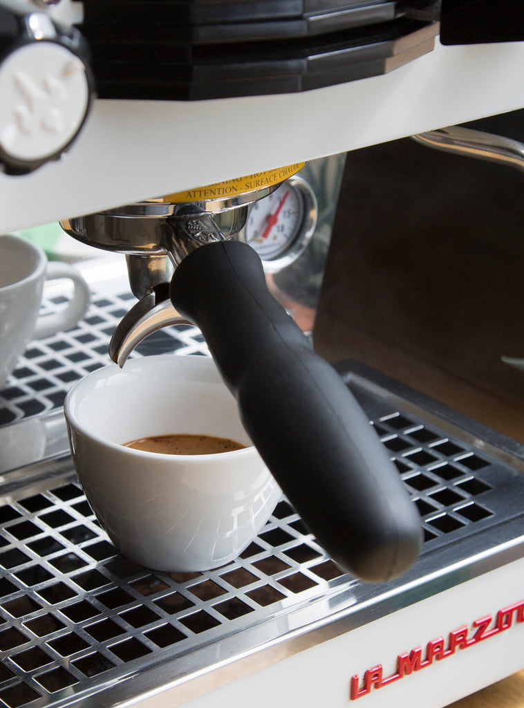 Photo of espresso in a cup under a porta filter in a la marzocco home machine.