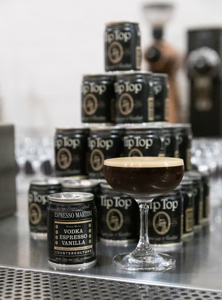 Photo of a pyramid of espresso martini cans with an espresso martini in front.
