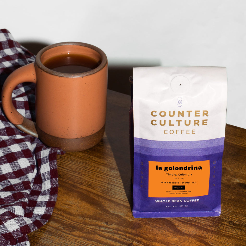Photo of a bag of La Golondrina coffee next to a mug.