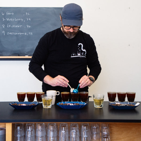 Photo of coffee buying Kyle cupping coffee as part of our work with World Coffee Research.