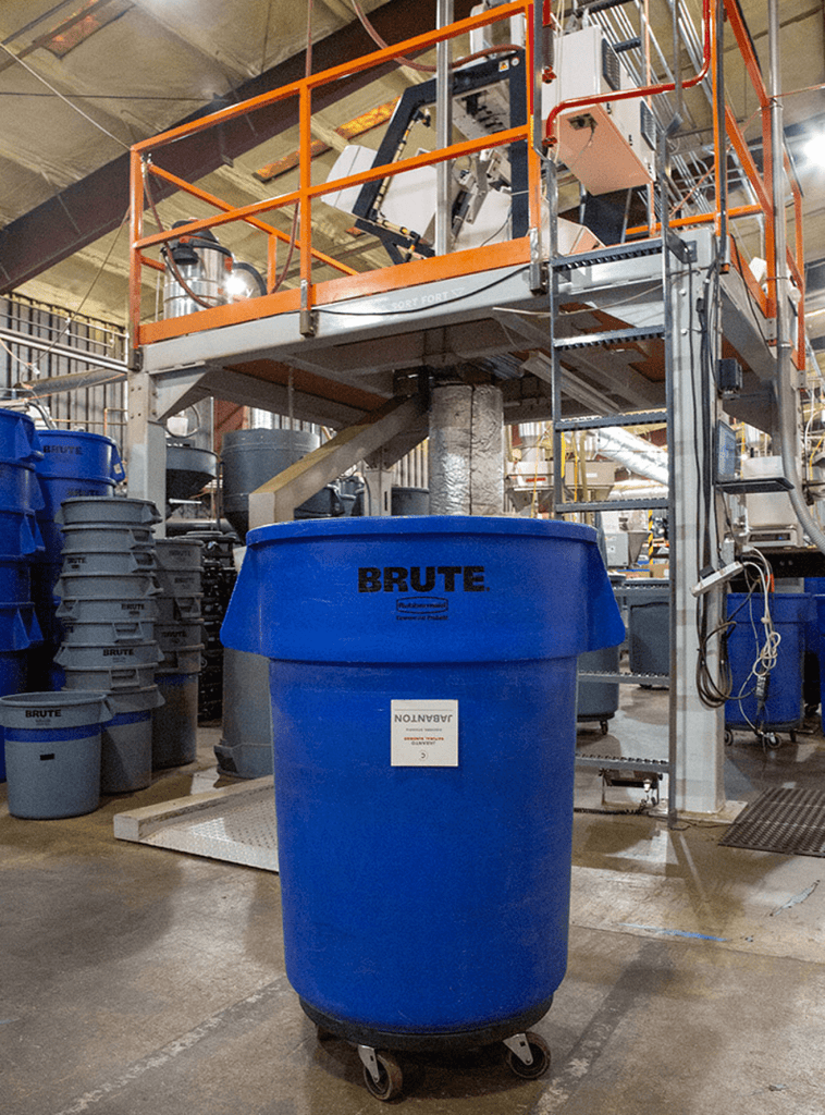 Photo of a large bucket on wheels in our roastery in front of the optical sorter.