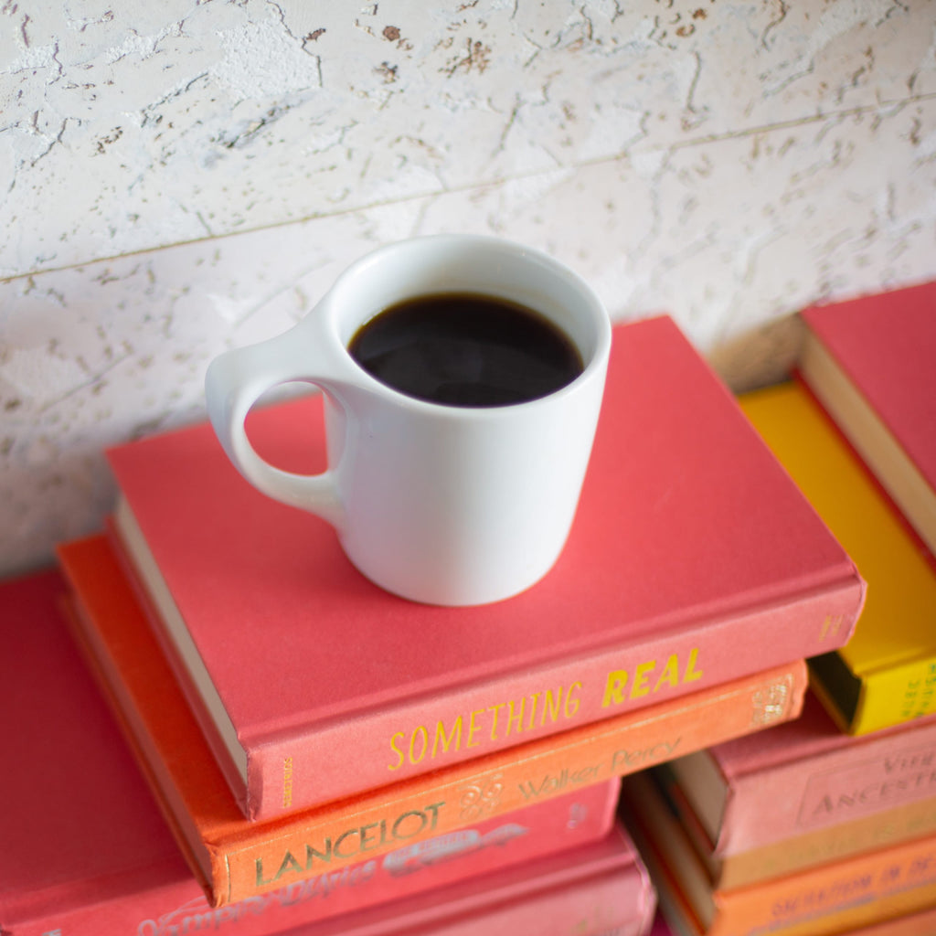 Photo of a mug of coffee on a stack of books.