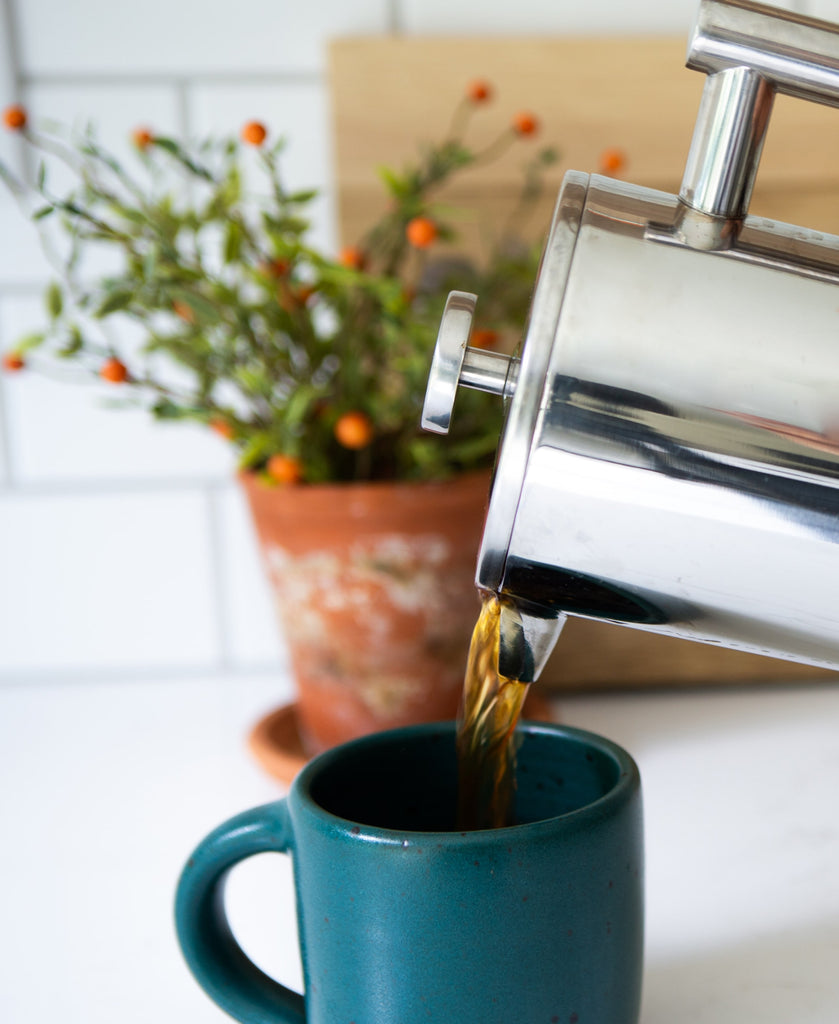 Photo of mug being poured into a mug from a French press.