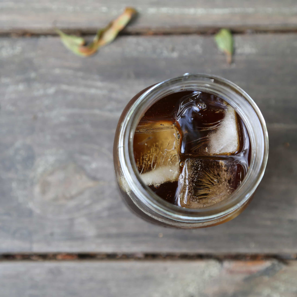 Top down photo of a glass of ice and cold coffee.