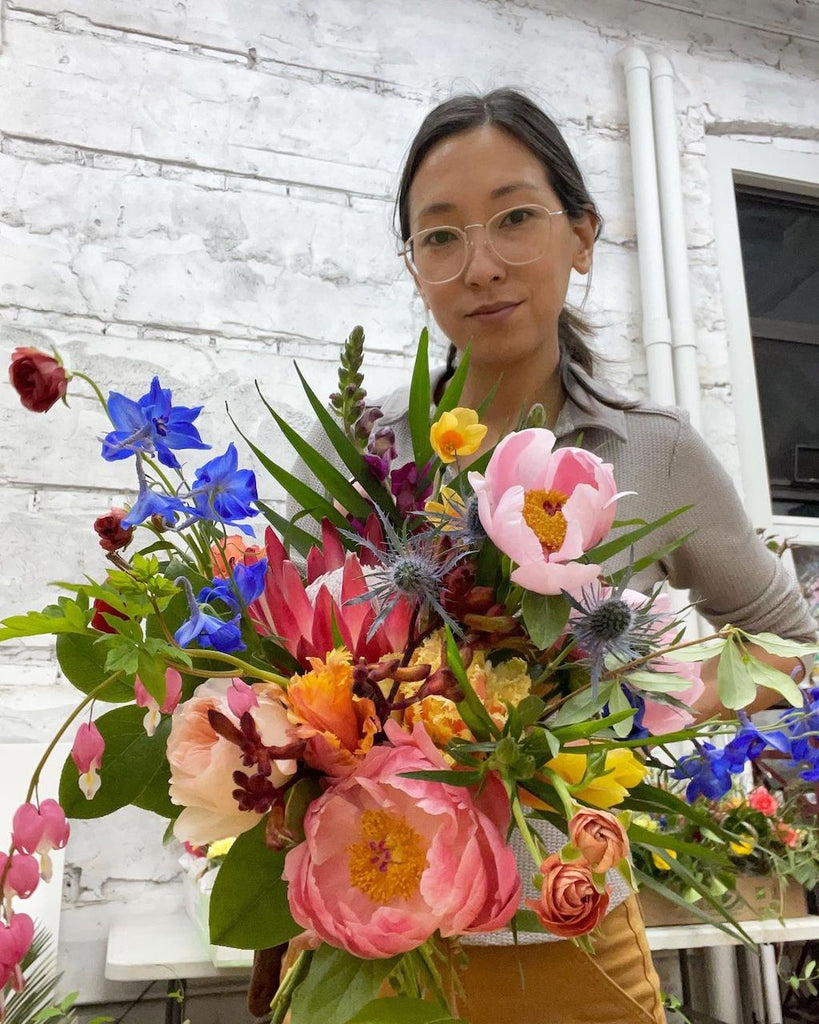 Photo of Kat Claar holding a bouquet of flowers.