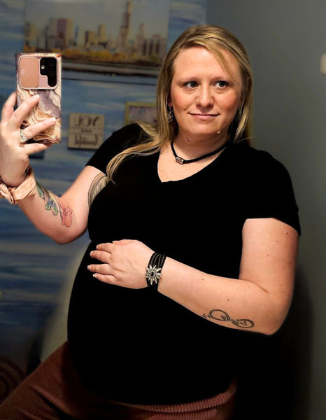 Pregnant woman taking a selfie wearing edelweiss jewelry and edelweiss accessories