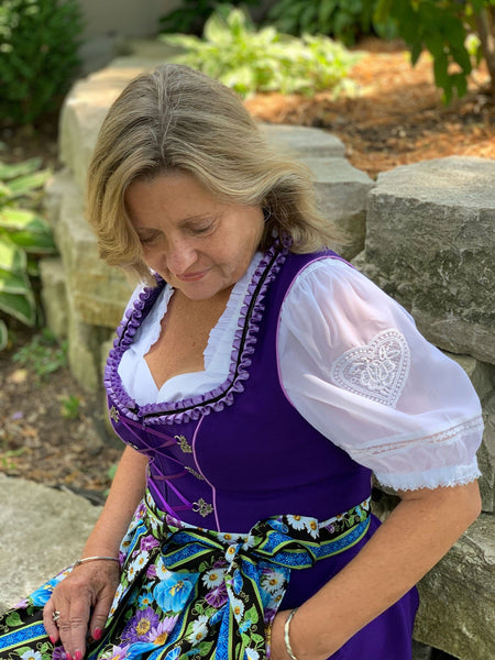 woman wearing an oktoberfest ladies costumes with a while dirndl blouse