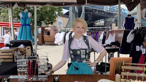 dirndl designer erika neumayer standing behind a booth selling dirndls at German fest in milwaukee