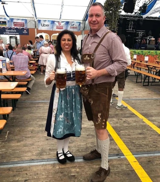 woman in a dirndl dress standing with a man in lederhosen in a beer tent at Oktoberfest in Munich