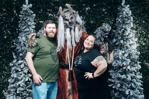 two people posed with folkloric figure austrian villagers at krampus parade