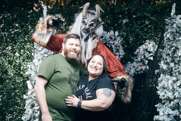 man wearing a krampus t-shirt standing with a woman and krampus