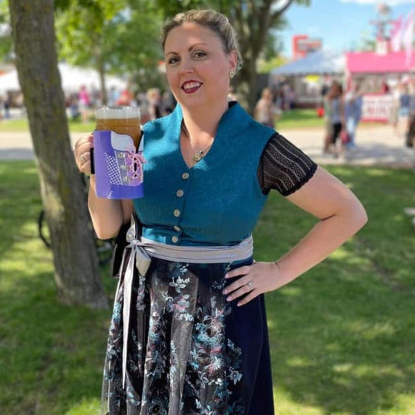 Girl in a plus size dirndl holding a liter of beer posing for the picture at German Fest Milwaukee