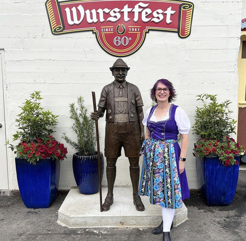 woman wearing a purple dirndl dress as wurstfest a German Fest in new braunfels 