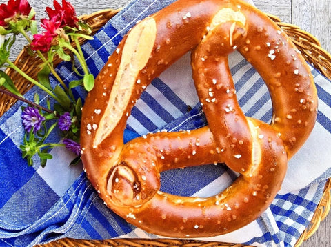 image of a large pretzel on a blue and white tablecloth with flowers on the side