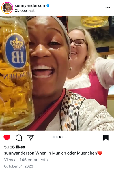 Two women smiling while they wear bavarian oktoberfest costumes at okotberfest in munch with a while blouse