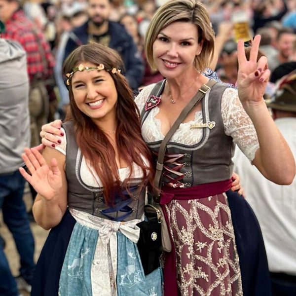 two women wearing dirndl dresses at oktoberfest in munich with white dirndl blouses - dirndl outfit