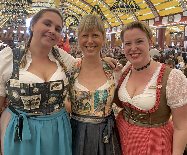 three women smiling in dirndls at oktoberfest in munich
