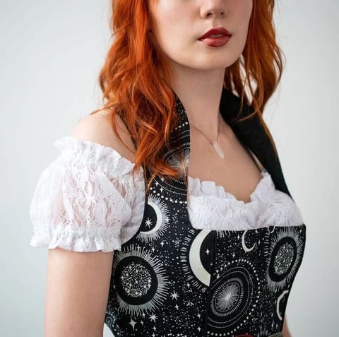 Woman in white black off the shoulder blouse with black dirndl