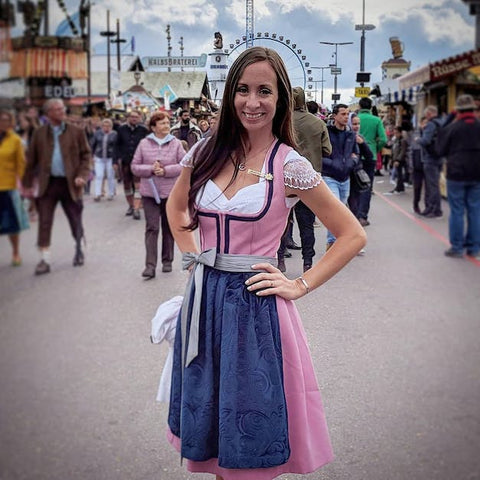 woman at oktoberfest with long dark hair wearing a pink dirndl dress - how to pack for oktoberfest