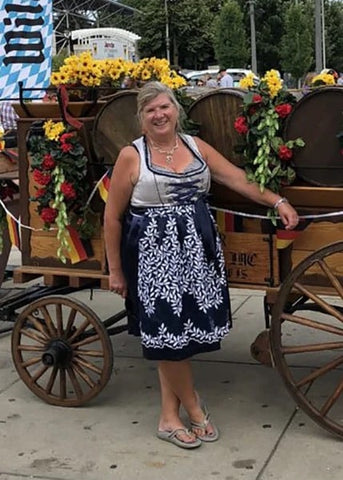 Woman wearing a plus size dirndl in front of an oktoberfest barrel wagon celebrating german culture at German Fest Milwaukee