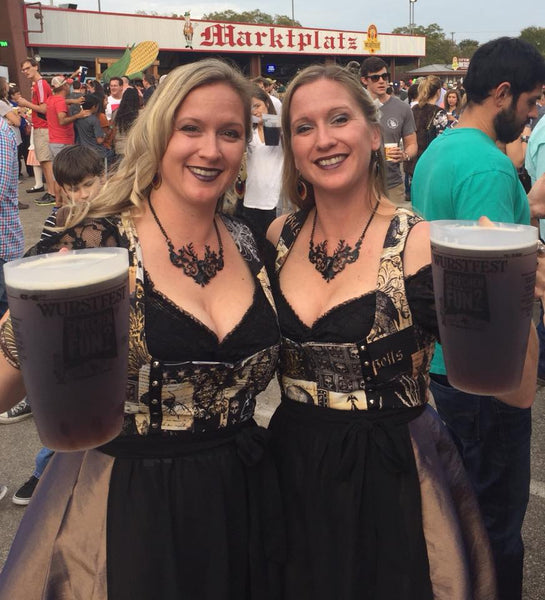 2 women in dirndl dresses at wurstfest in new braunfels Texas holding pitchers of German Beer