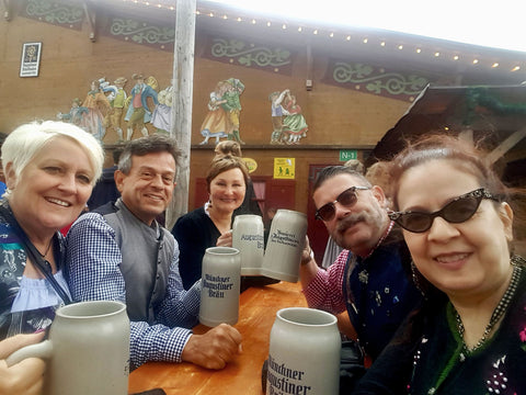 group of people attend oktoberfest at a table. great travel planning