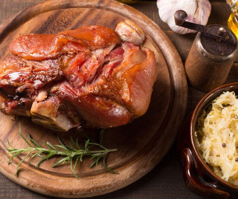 A popular Oktoberfest food, Pork knuckle or Schweinshaxe served with sauerkraut and potato salad