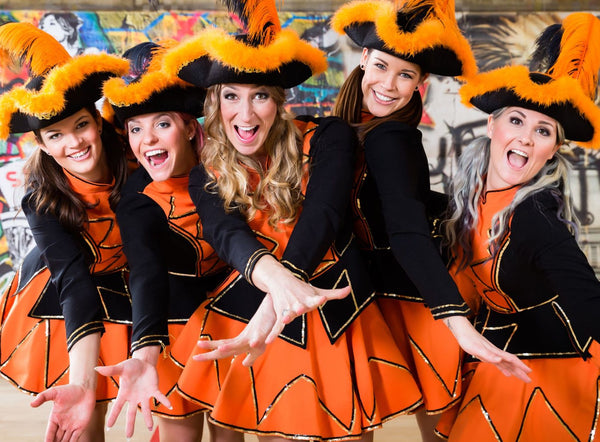 a group of german karneval dancers dressed in orange and black outfits with matching hats