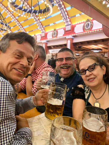 Maria, troy and her brother smiling holding liters of beer in the first beer tent at Oktoberfest