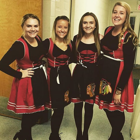group of girls wearing red dirndls with black long sleeves shirts as dirndl blouses