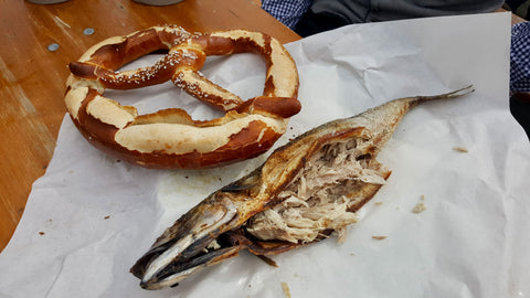 a steckerlfisch with a pretzel on a table at oktoberfest in munich