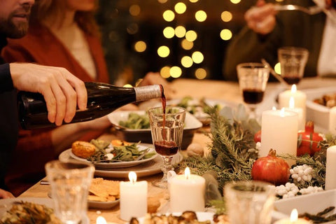 someone pouring a glass of wine during christmas celebrations