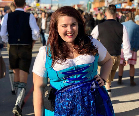 Woman wearing traditional garments from Germany. Shes wearing a blue German dirndl with white blouse