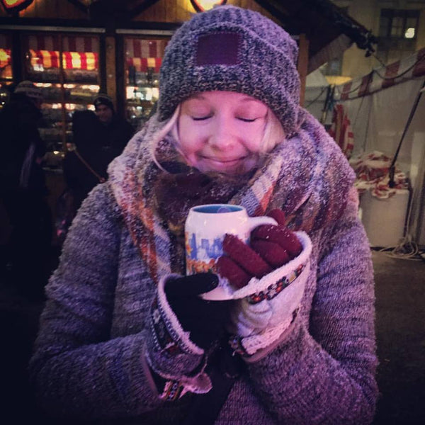 woman drinking warm drink at christmas market in late november