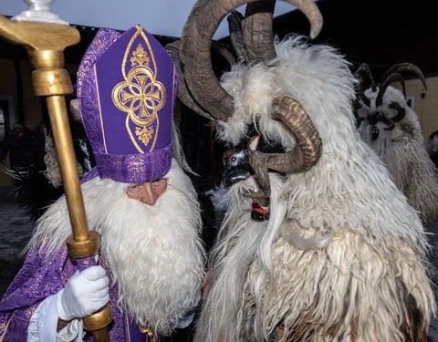 Two people in costumes. One in krampus costume and the other as St. Nicholas