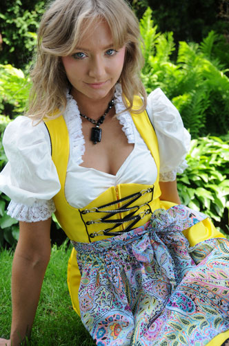 girl wearing a yellow dirndl with paisley apron and white dirndl blouse